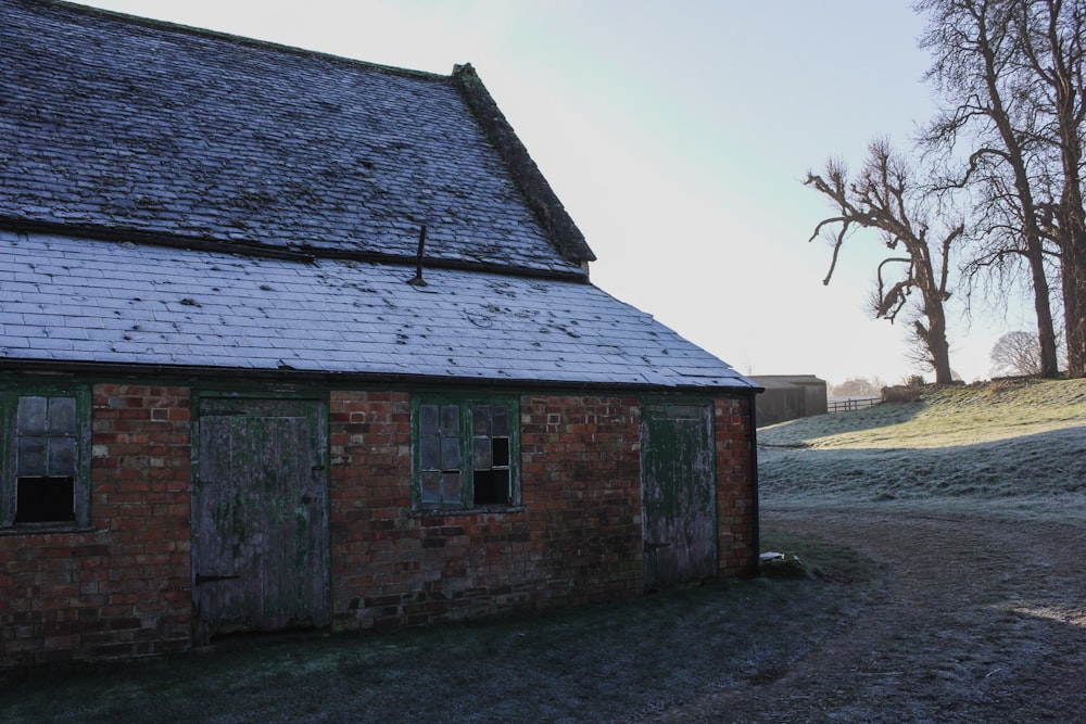 brown brick house near bare tree during daytime