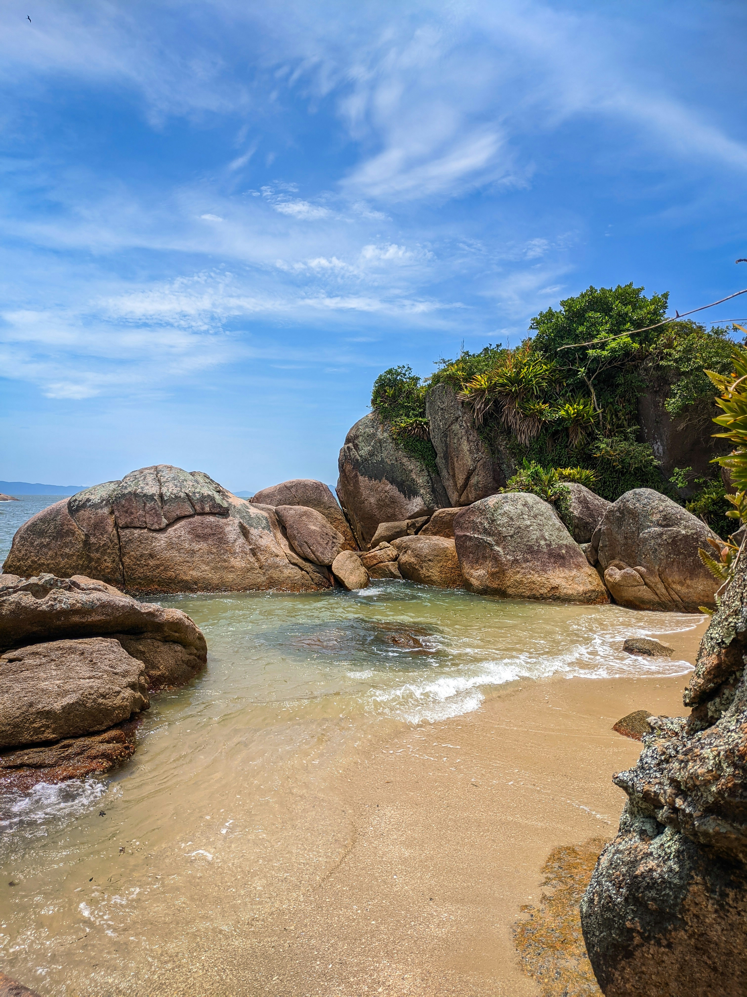 formazione rocciosa marrone sullo specchio d'acqua durante il giorno