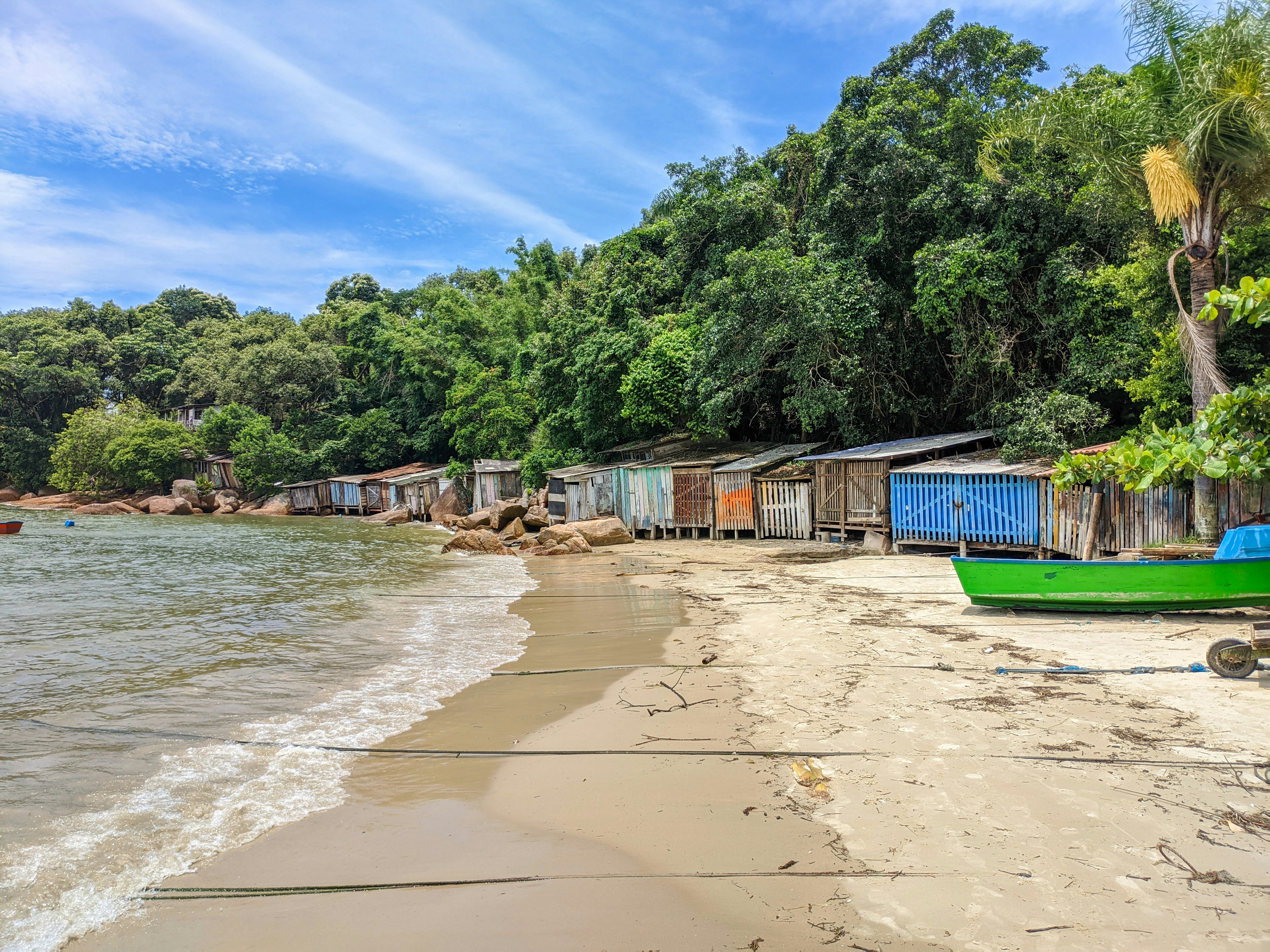 barco verde e azul na costa perto de árvores verdes durante o dia