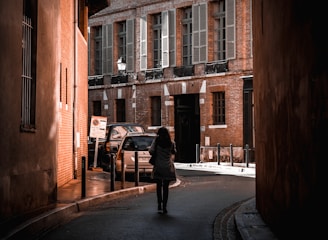 man in black jacket walking on sidewalk during daytime
