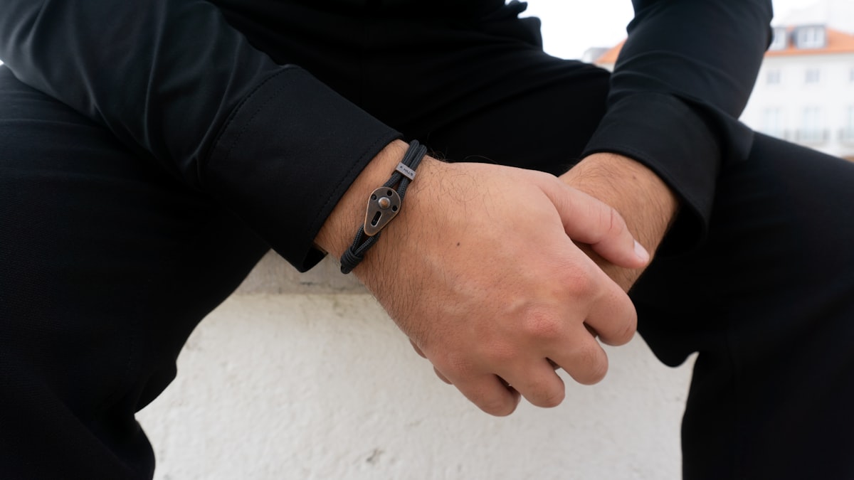 Gros plan d'un poignet masculin portant un bracelet à maillons en acier argenté