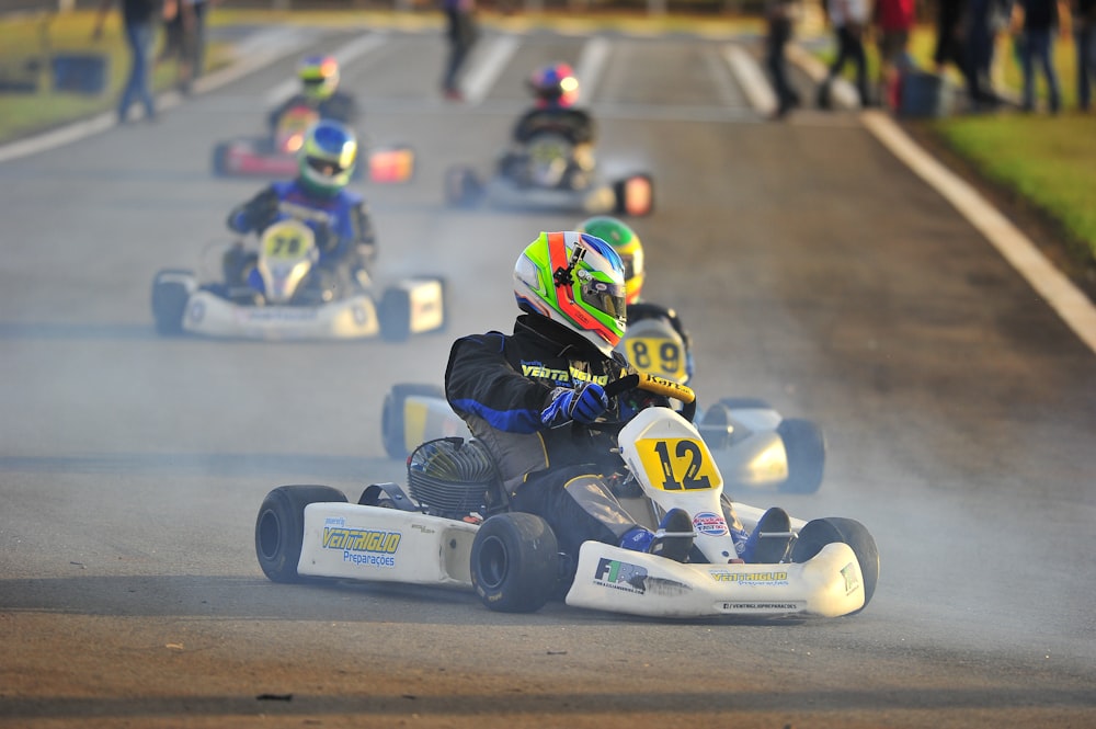 person riding on white and blue go kart