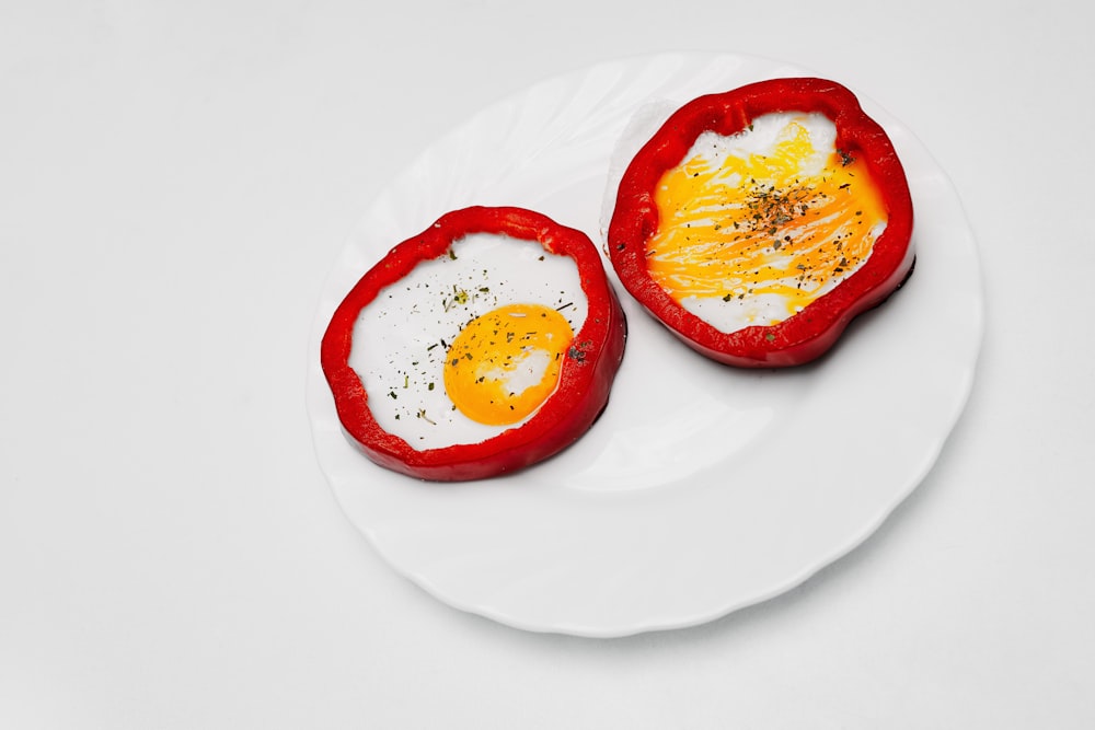 two red fruits on white ceramic plate