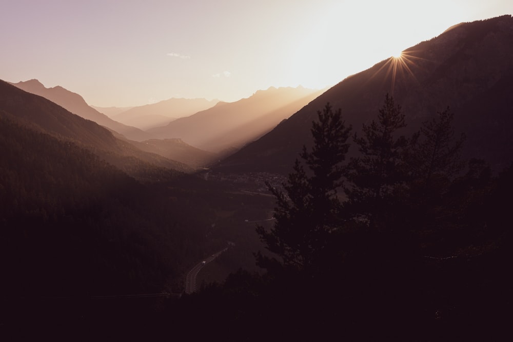 silhouette of trees and mountains during sunrise