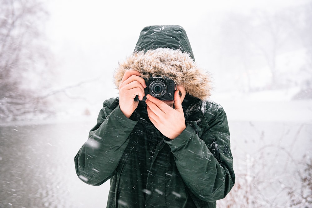 person in black leather jacket holding black camera