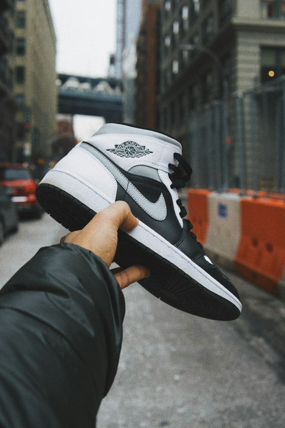 person holding white and black nike basketball shoes