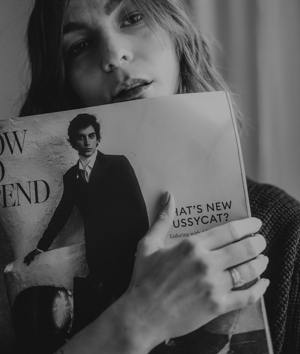 woman in black blazer holding book