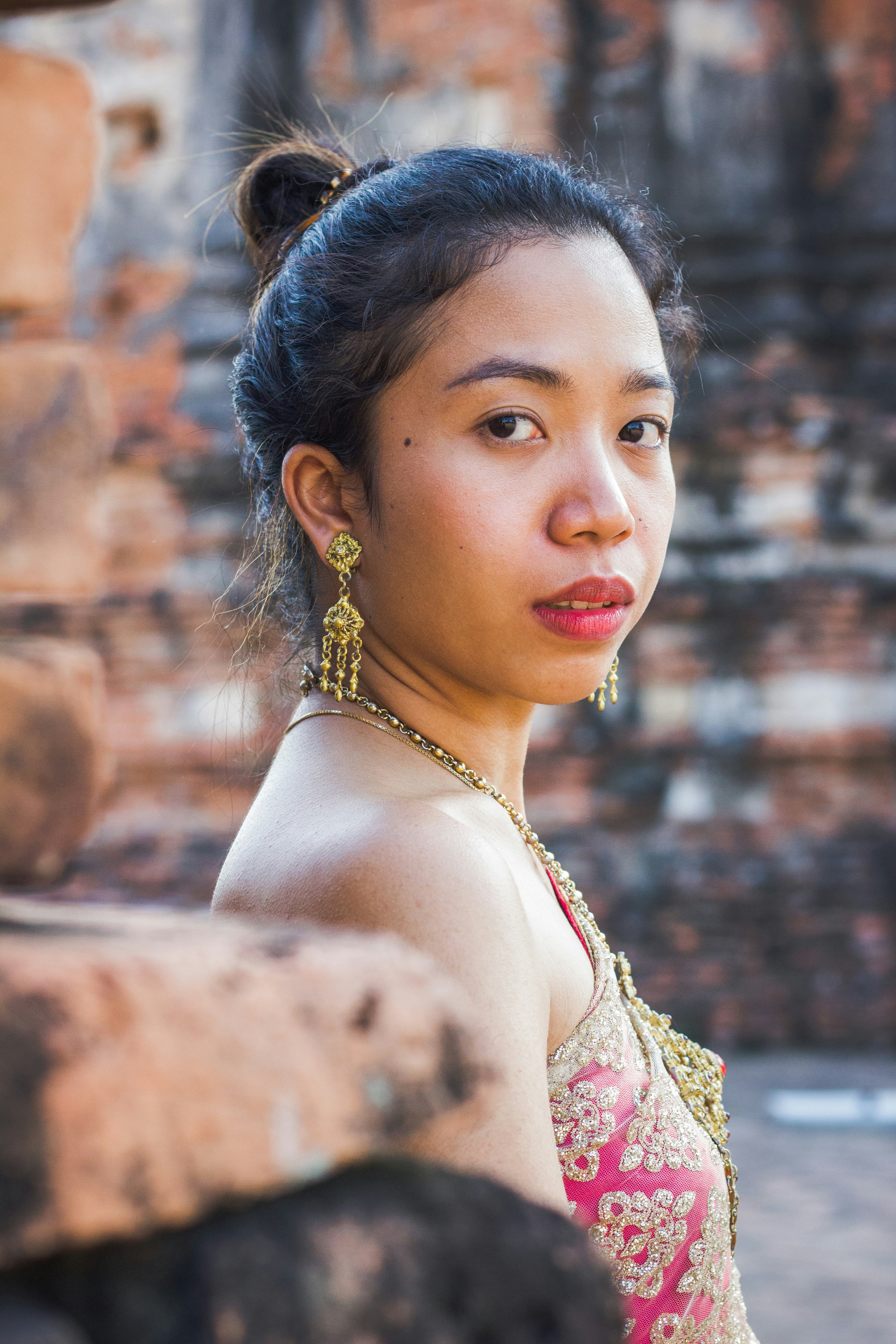 woman in gold and red floral dress