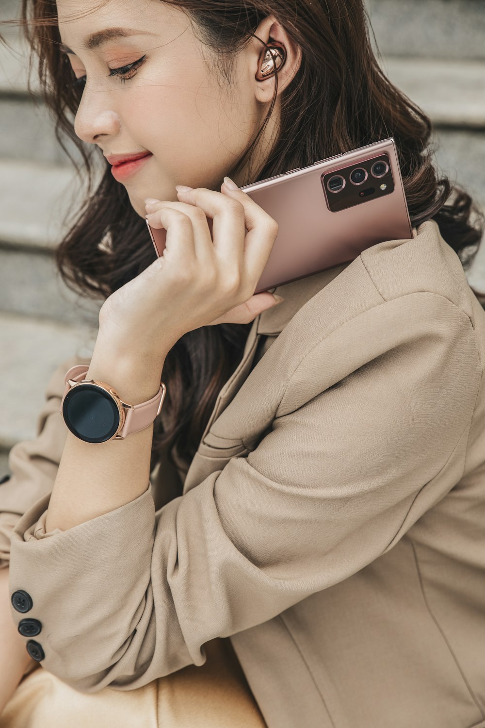 woman in brown coat holding silver iphone 6