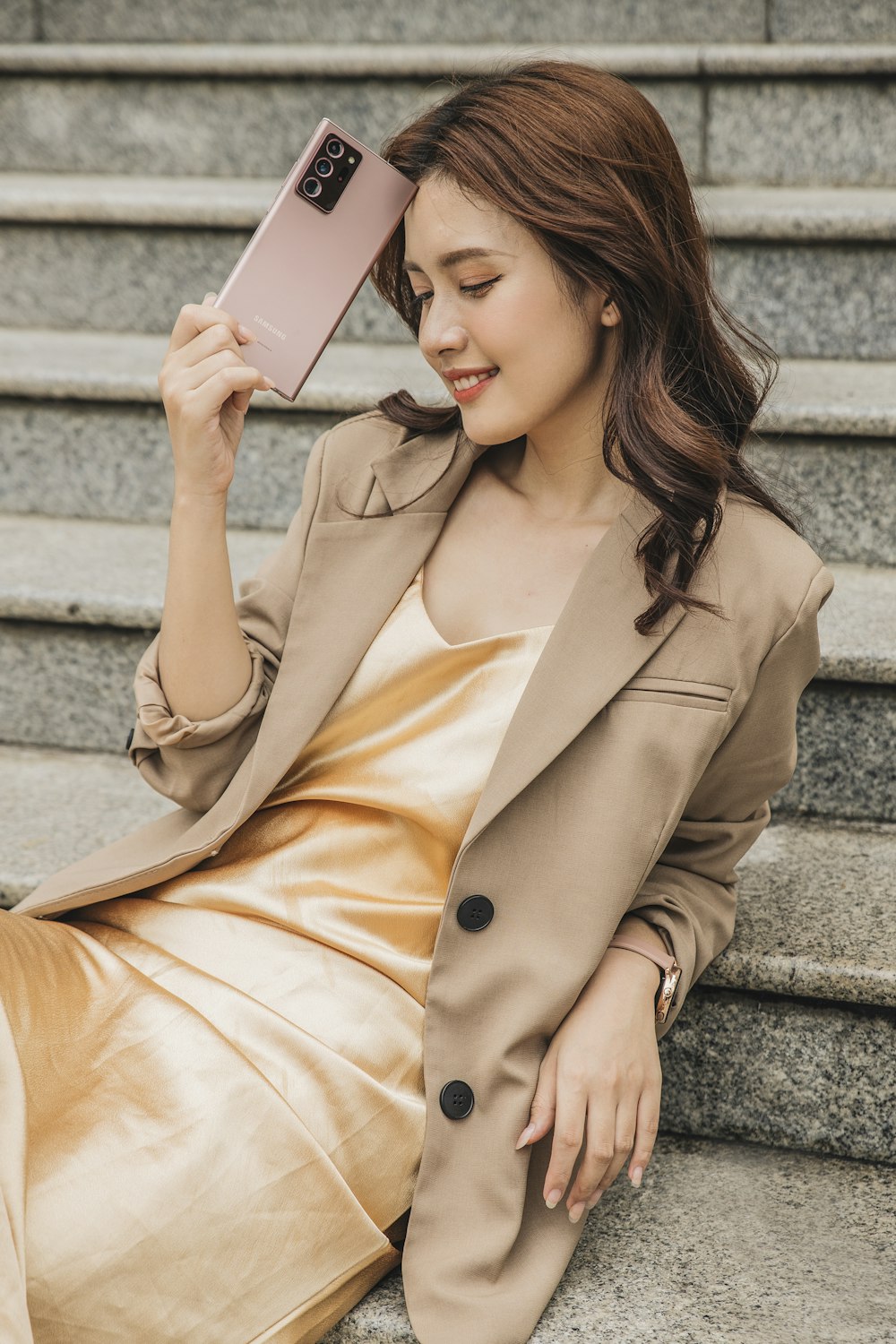 woman in brown coat holding white book