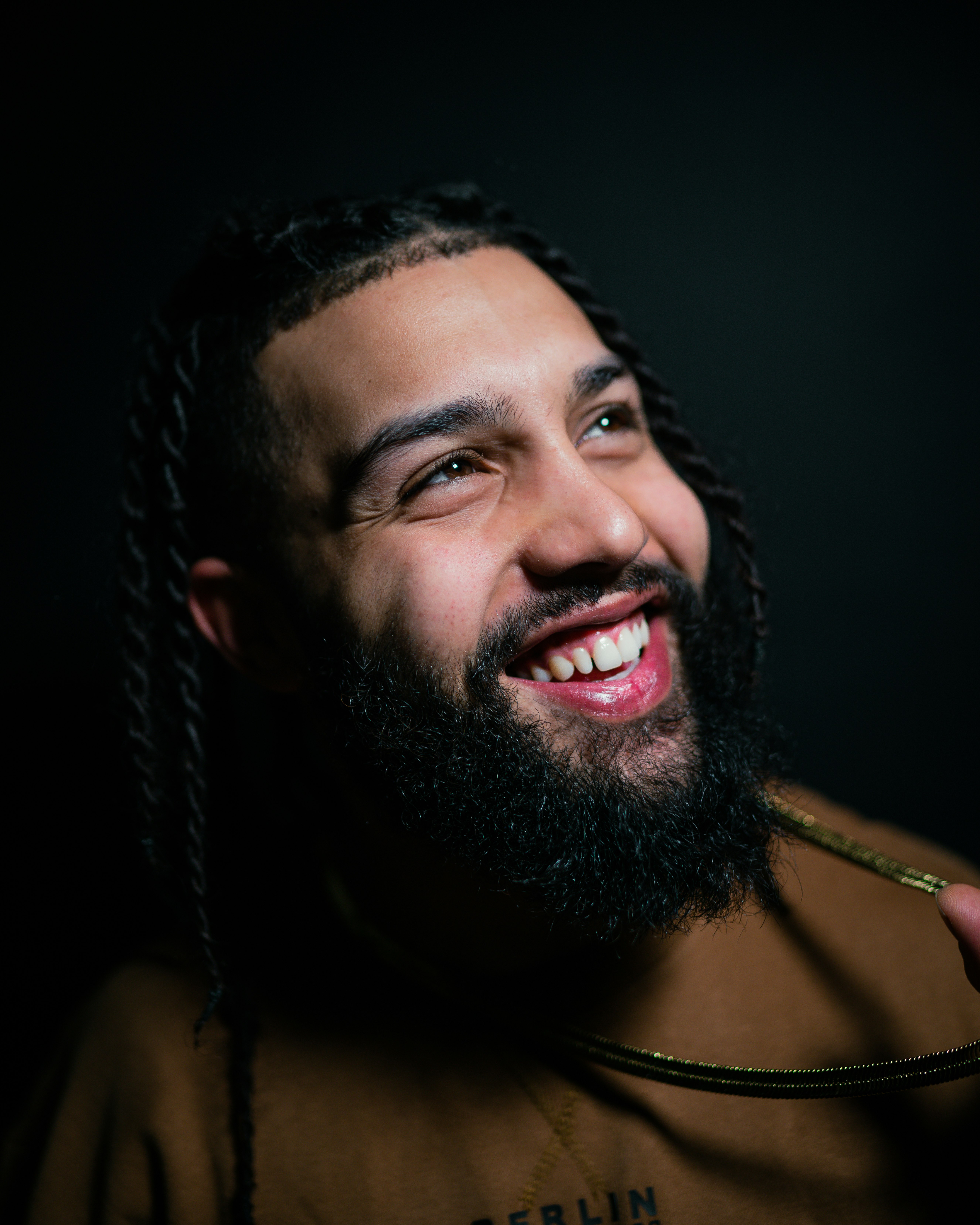 man with black beard wearing gold necklace