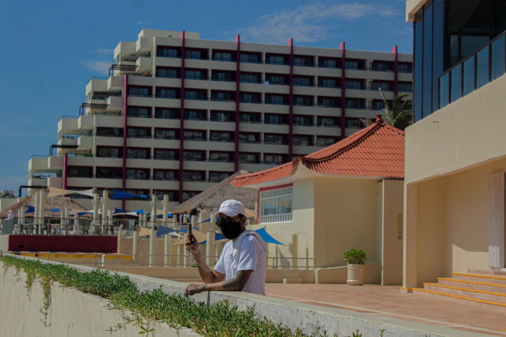 man in white t-shirt sitting on white concrete bench during daytime