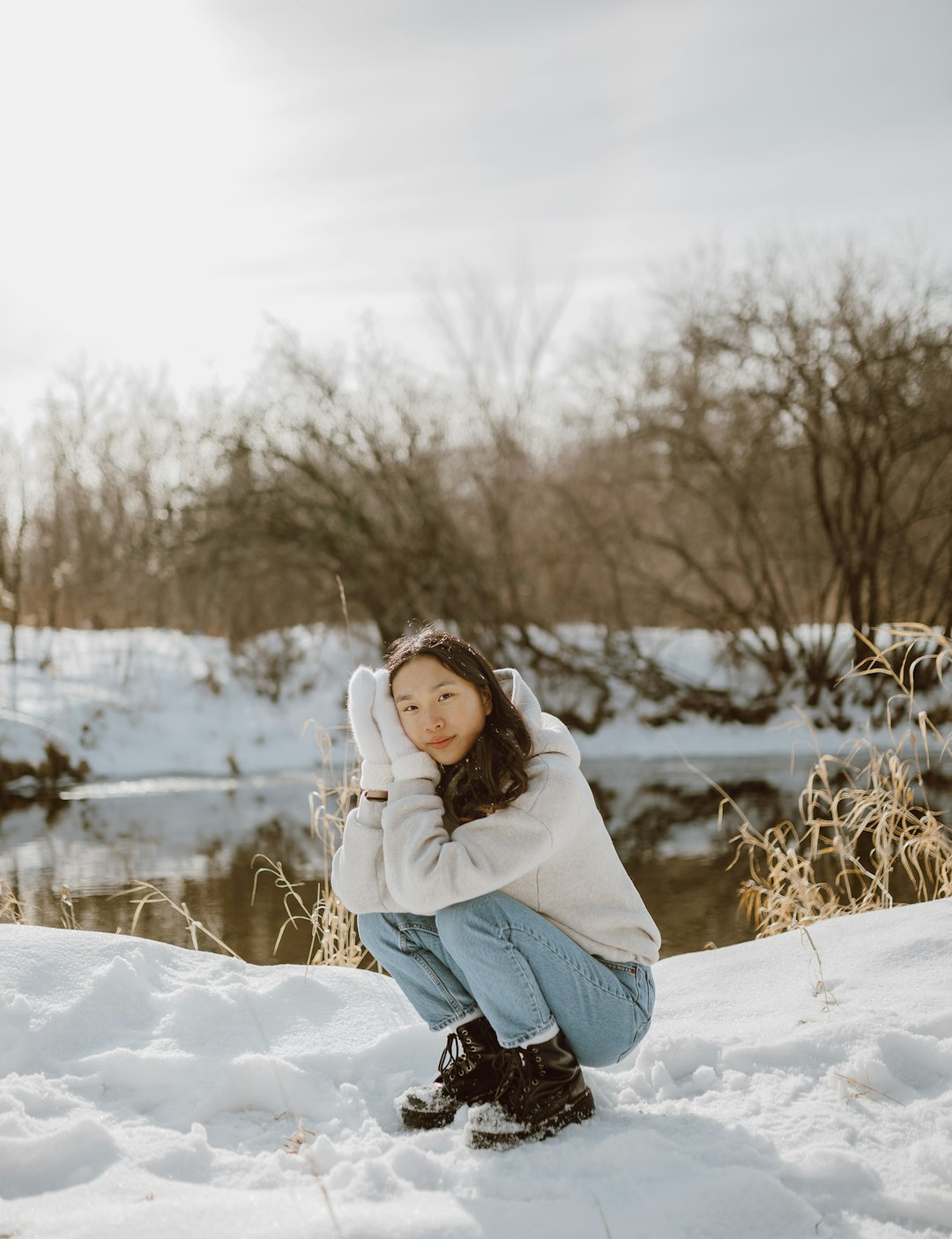 woman in white jacket and black pants standing on snow covered ground during daytime