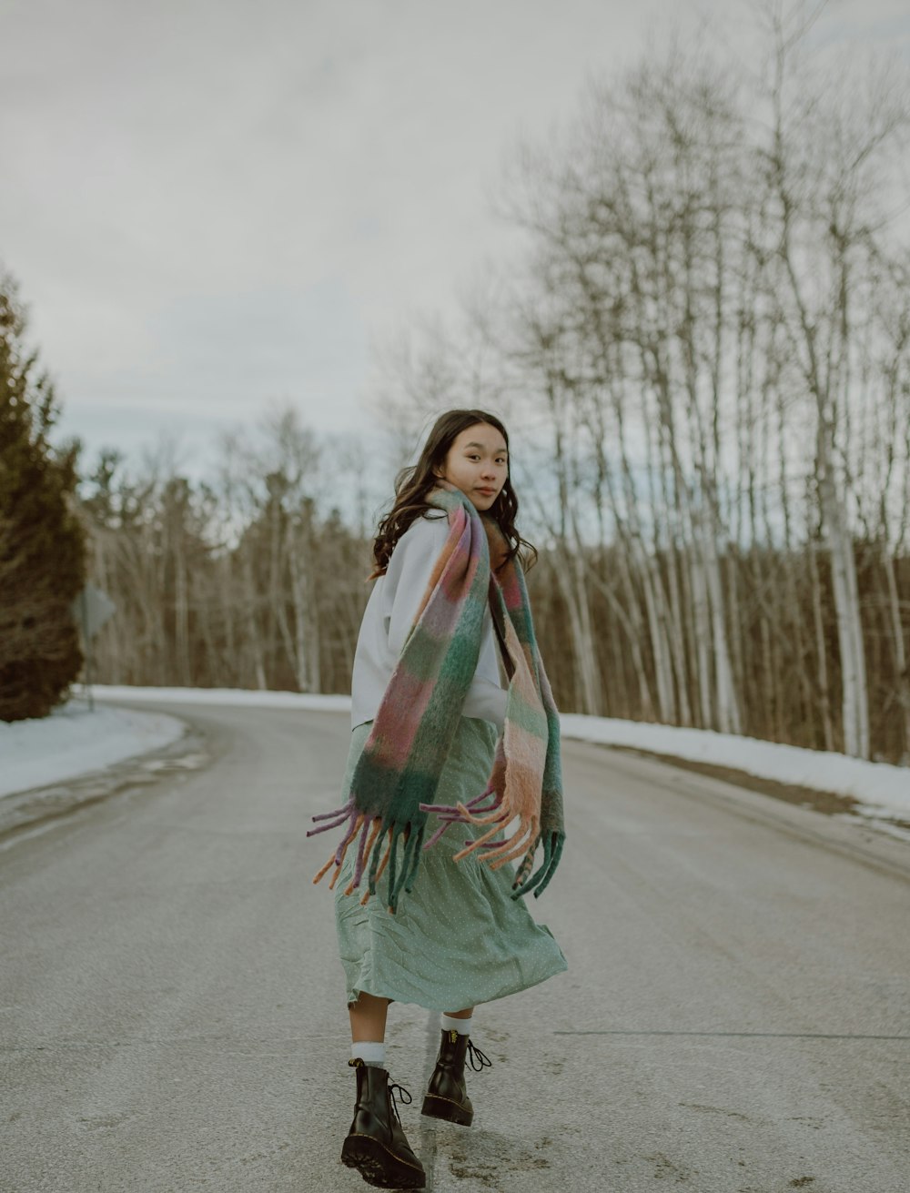 woman in green white and red scarf standing on road during daytime