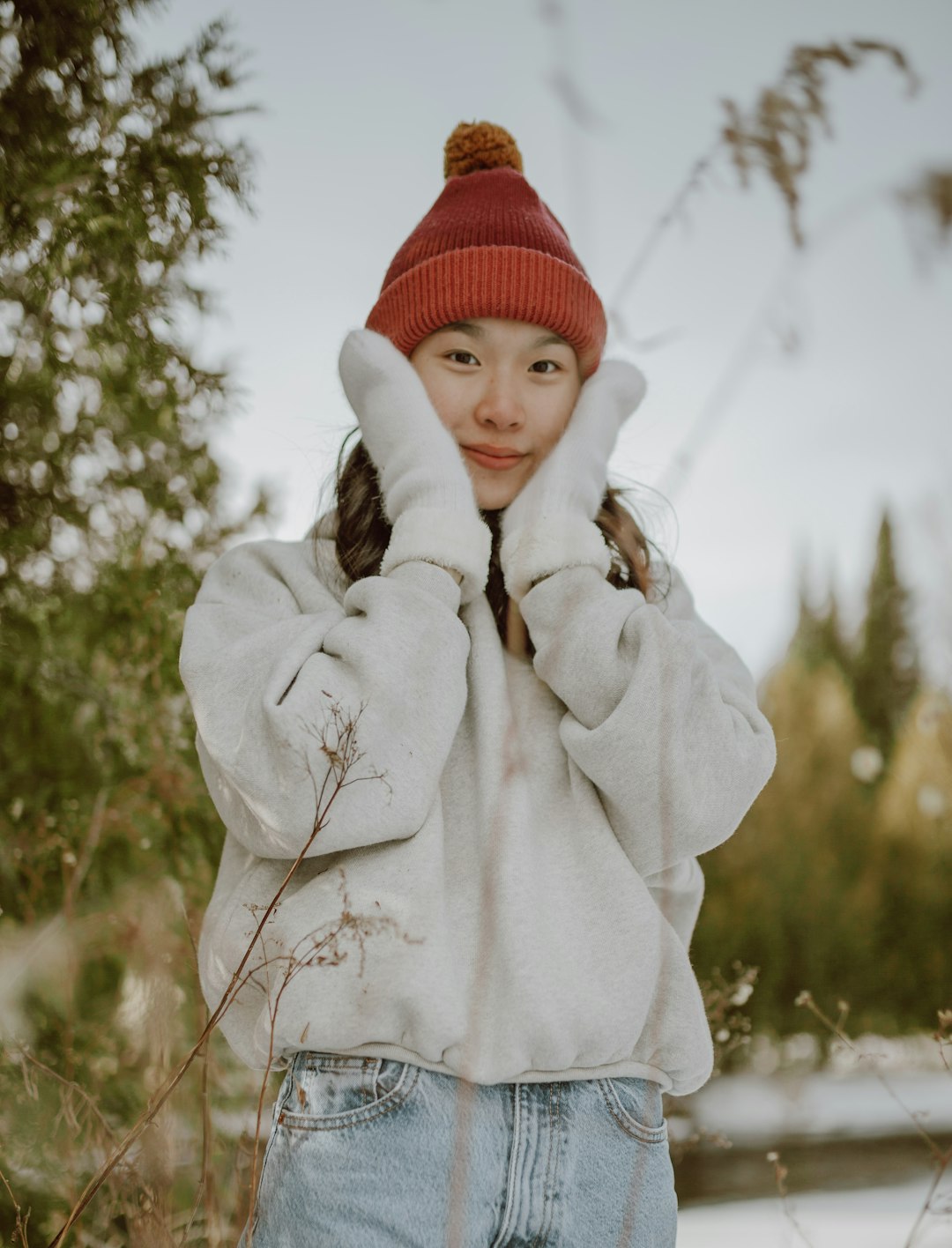 child in red knit cap and white hoodie