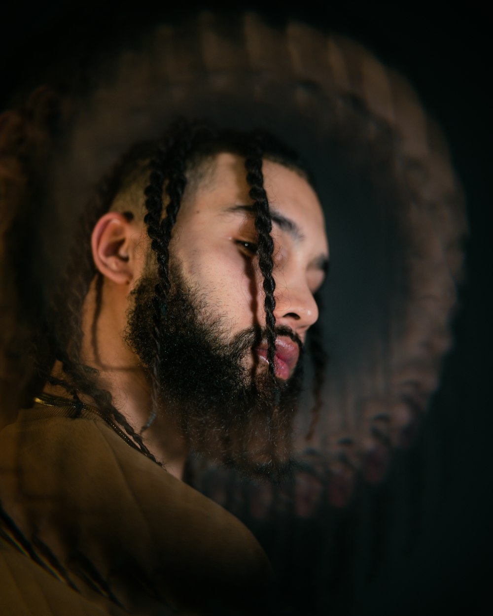 man in brown hoodie with black braided hair