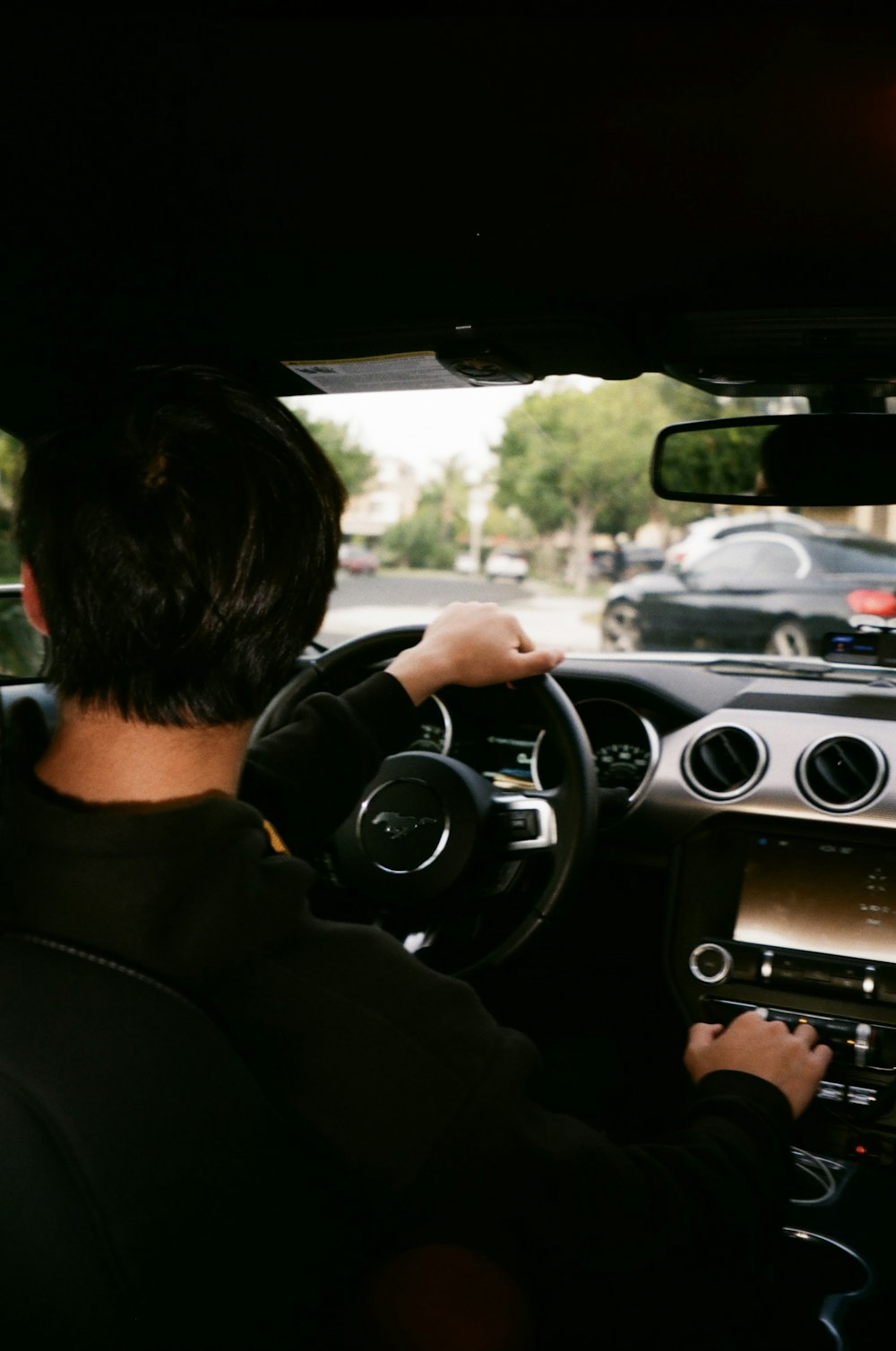 man in black jacket driving car during daytime