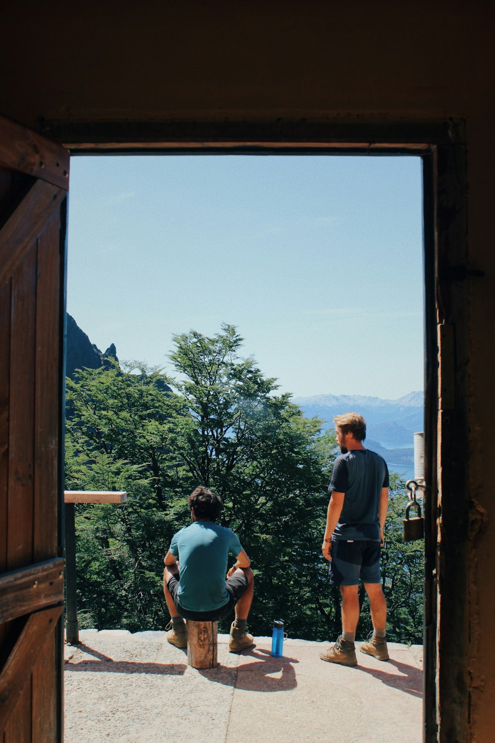 man and woman standing on brown wooden bridge during daytime