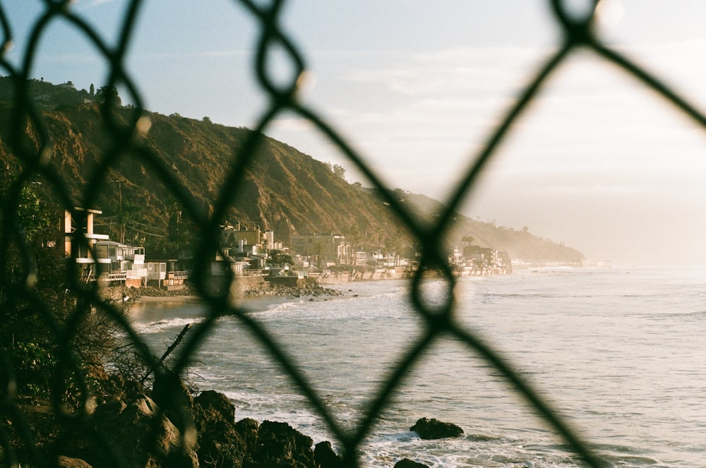 gray metal fence near body of water during daytime