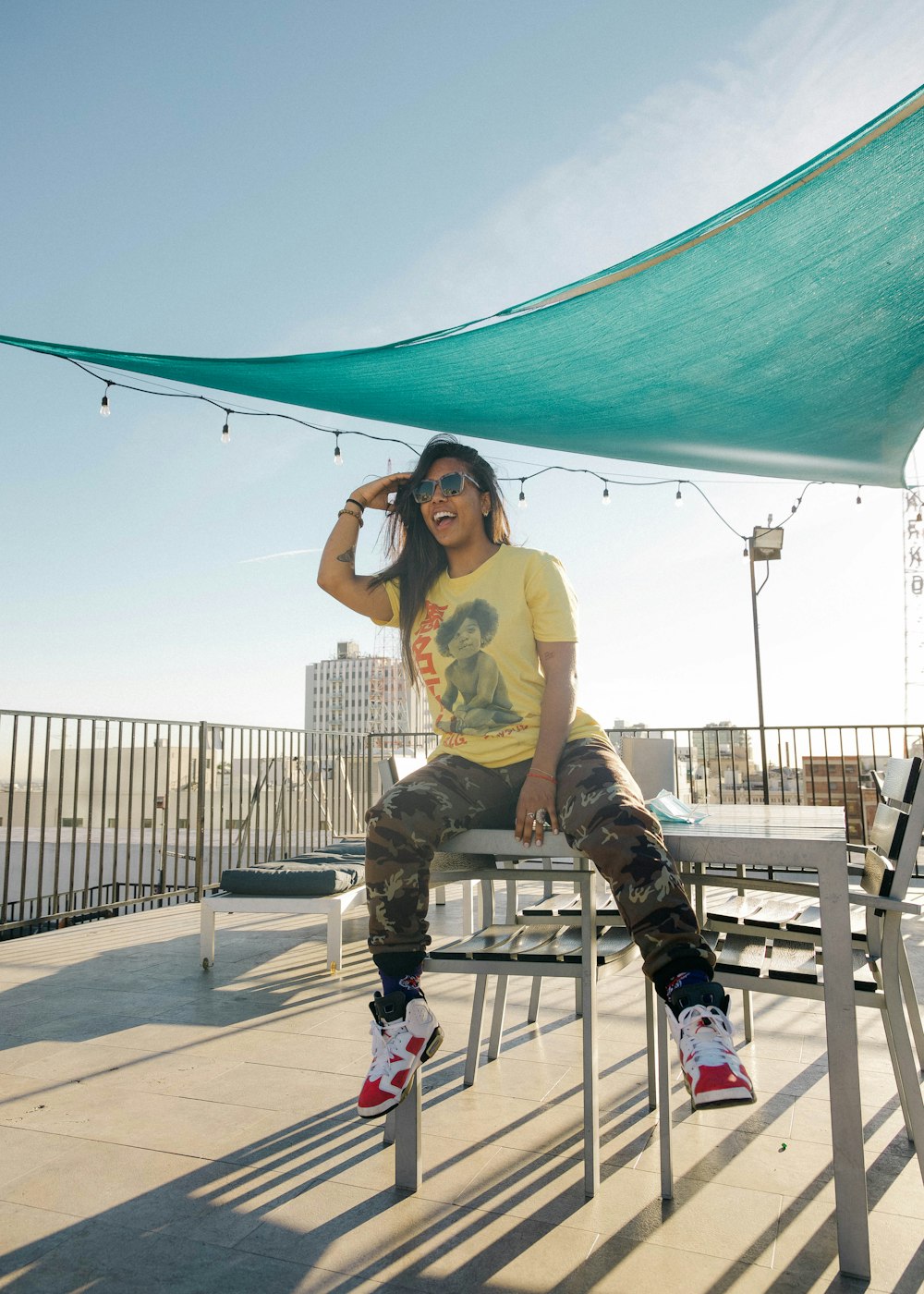 woman in yellow t-shirt and black pants sitting on white wooden bench during daytime