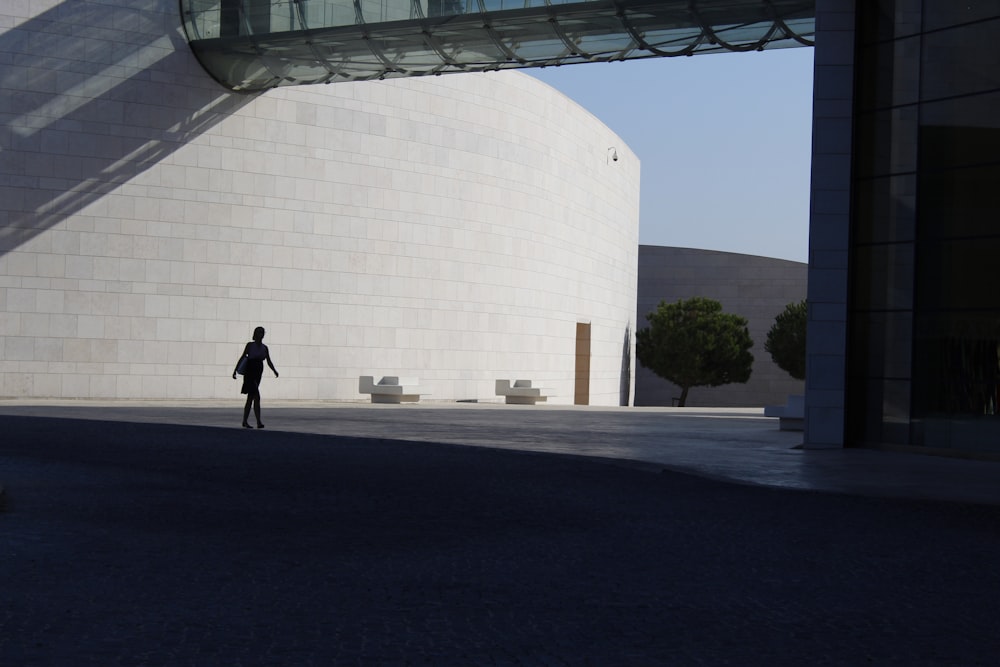 man in black jacket walking on sidewalk during daytime