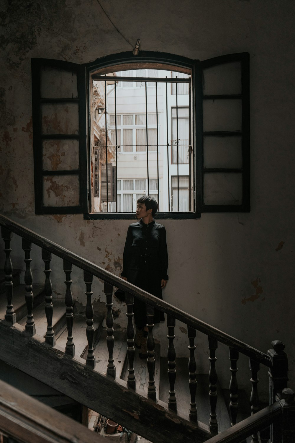man in black jacket standing on staircase