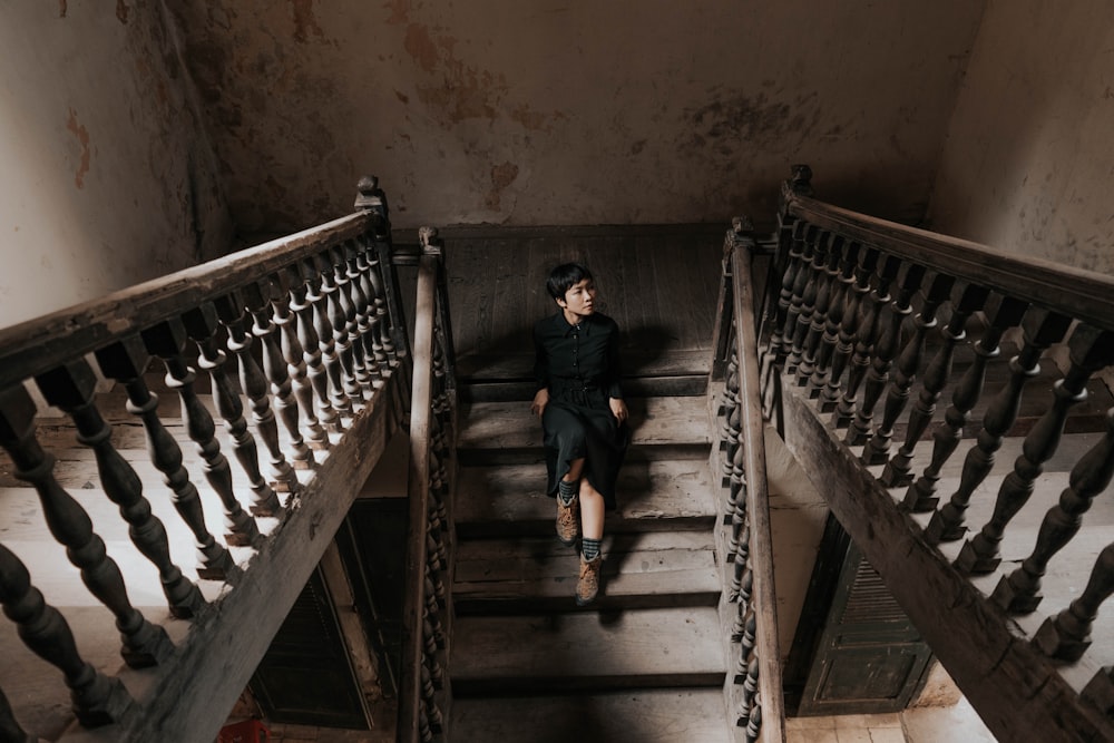 man in black shirt sitting on staircase