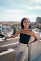 woman in black tube top and white and black leopard print skirt standing on bridge during