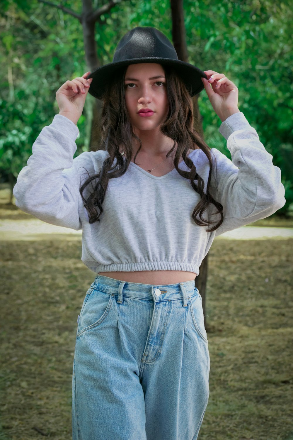 Una mujer joven con un sombrero negro y jeans