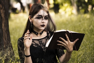 a woman with makeup on holding a book