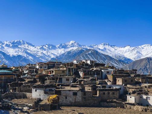 houses near snow covered mountain during daytime