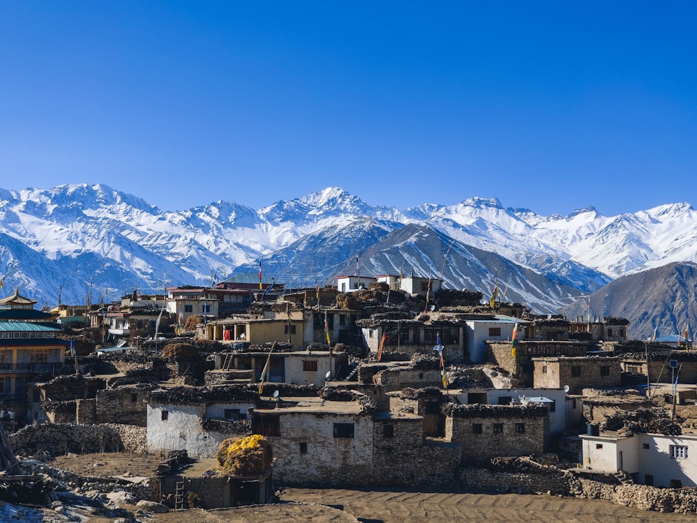 houses near snow covered mountain during daytime