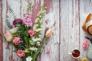pink flower on gray wooden plank