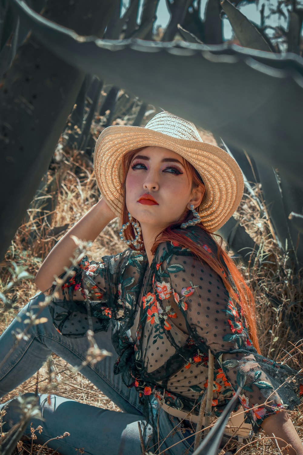 woman in brown straw hat and blue denim jeans