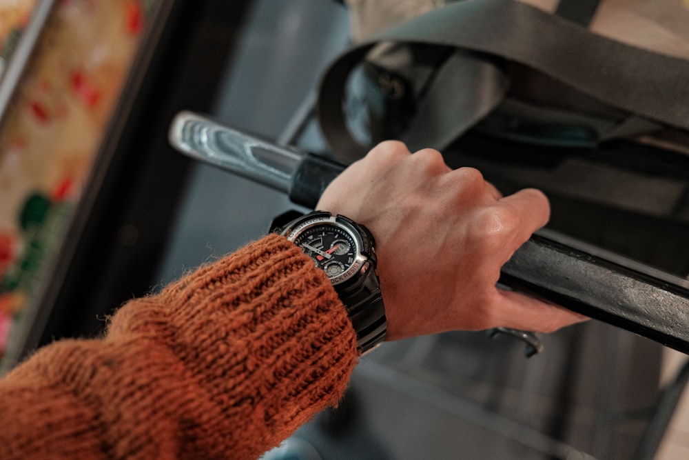 person in red sweater holding black steering wheel