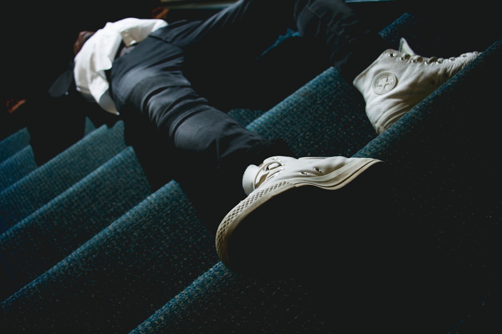 person in black pants and white sneakers