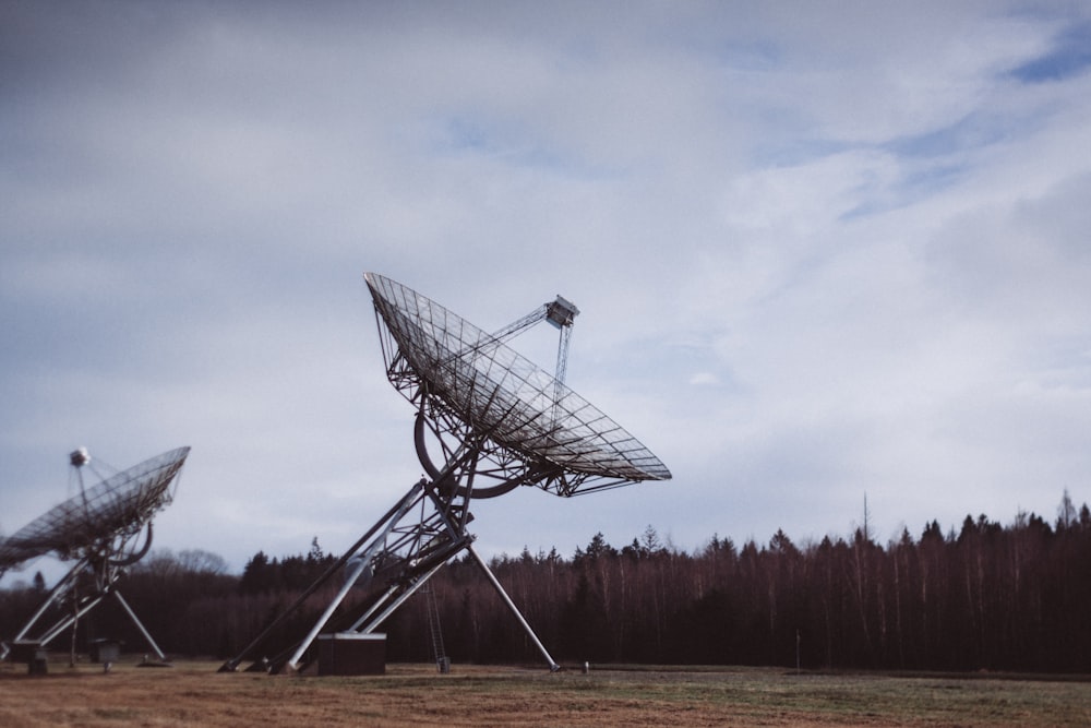 gray satellite dish on green grass field under white clouds during daytime