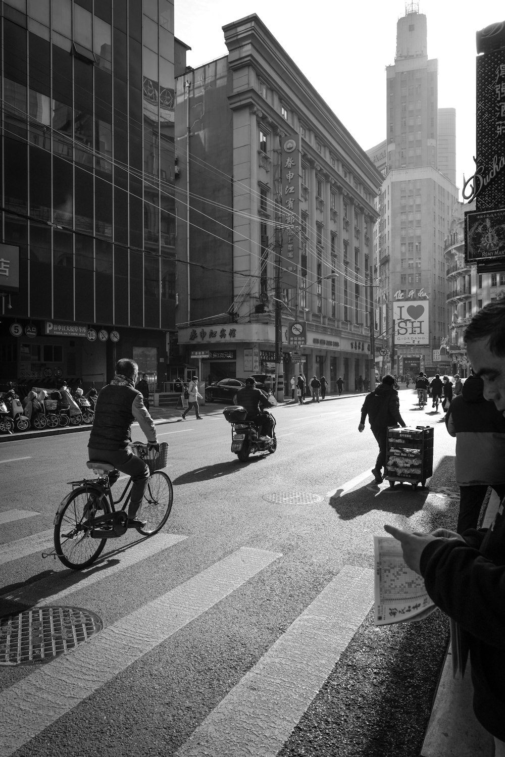 grayscale photo of people riding bicycle on road