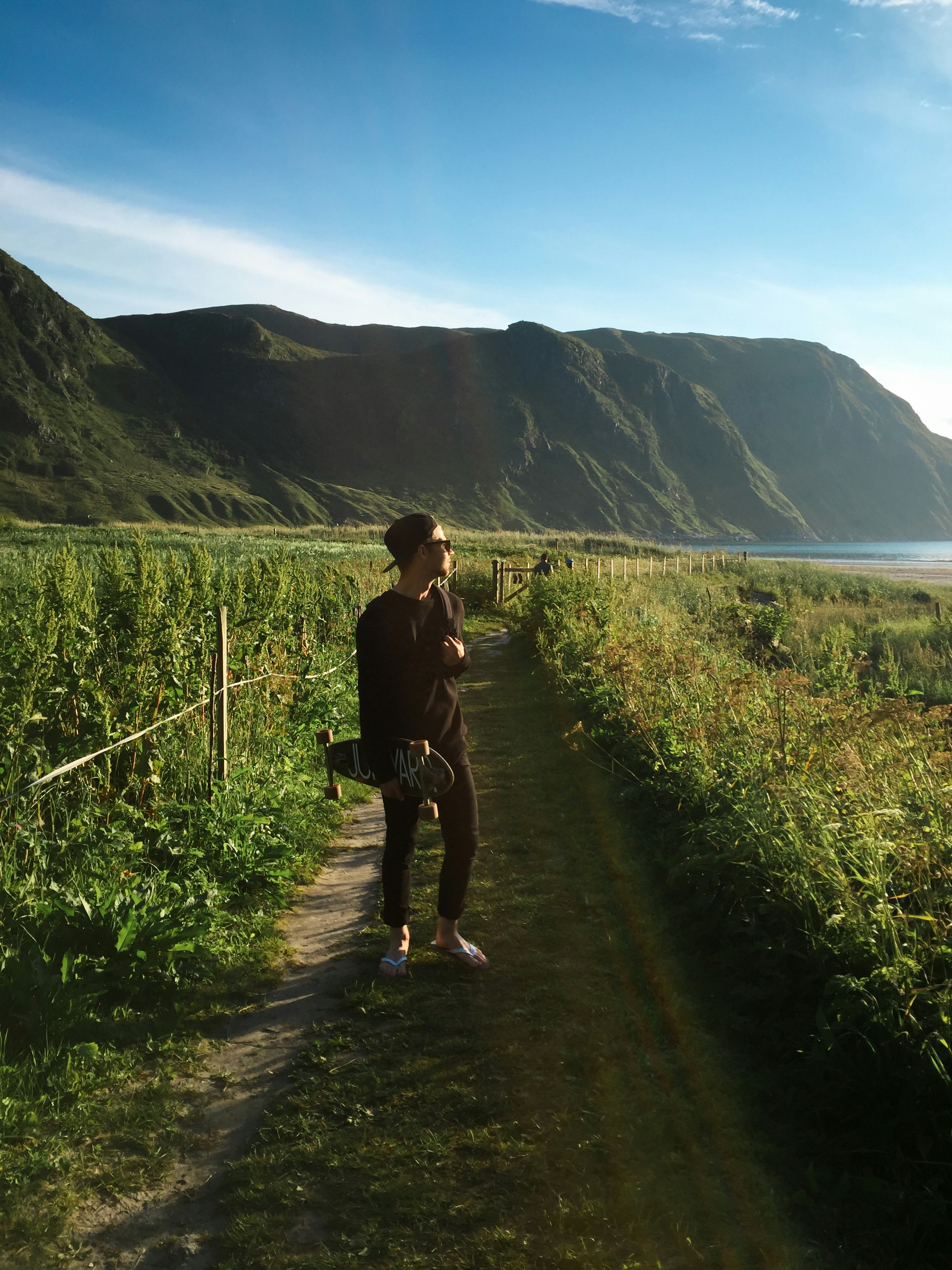man in black t-shirt and blue denim jeans walking on pathway during daytime
