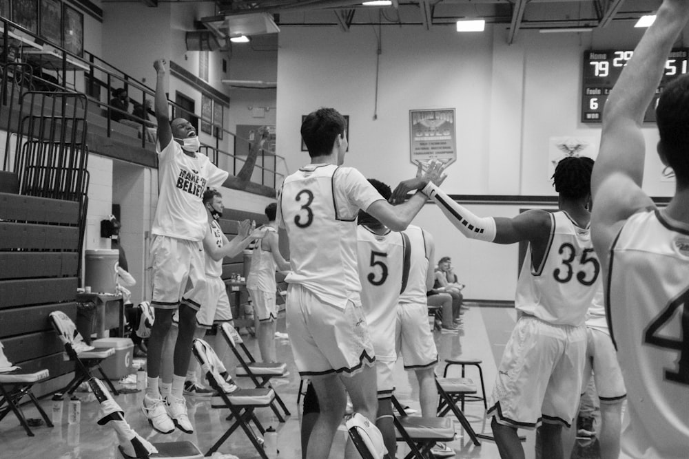 grayscale photo of basketball players in court