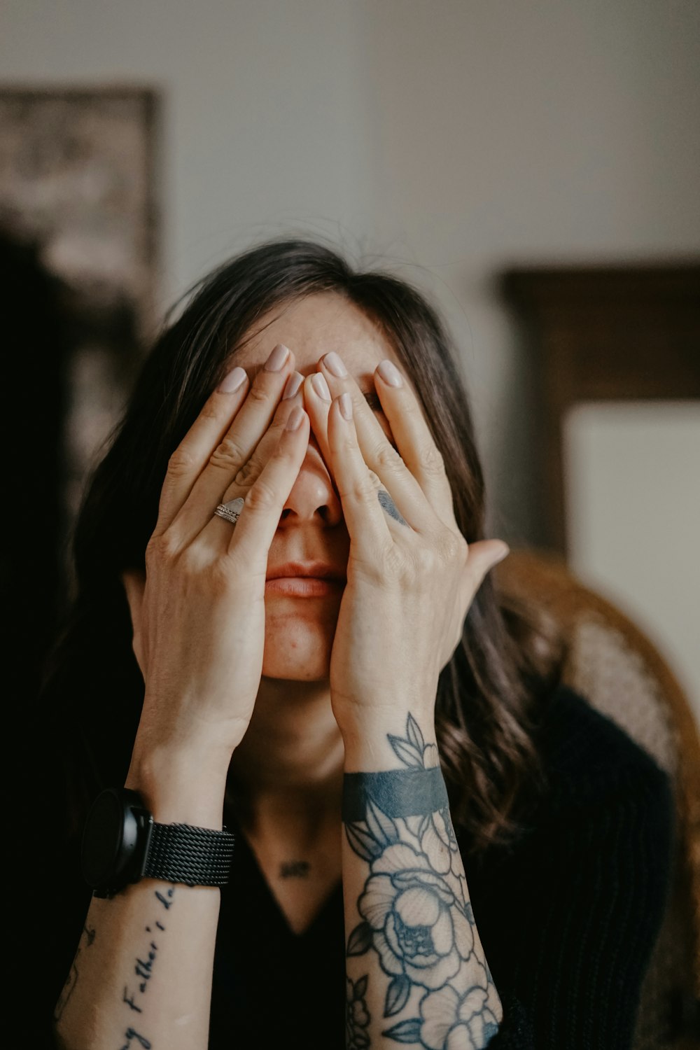 woman in black long sleeve shirt covering her face