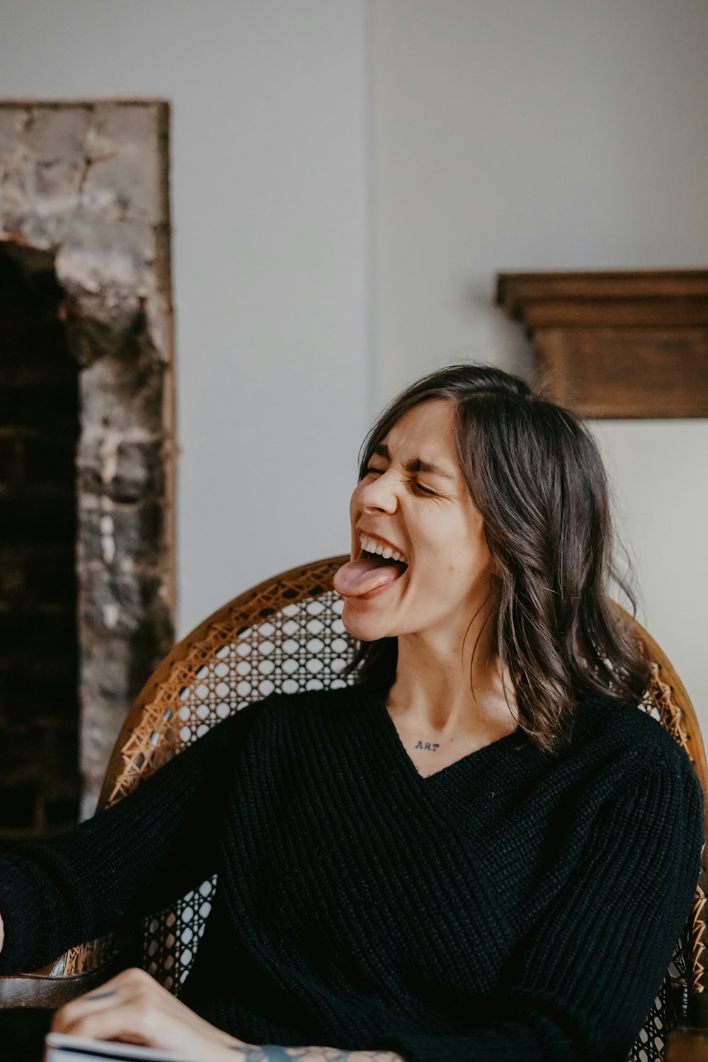 woman in black v neck shirt sitting on brown wicker chair