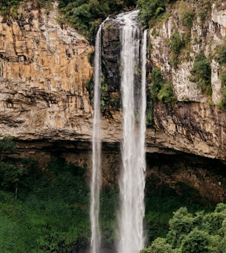 water falls on brown rocky mountain