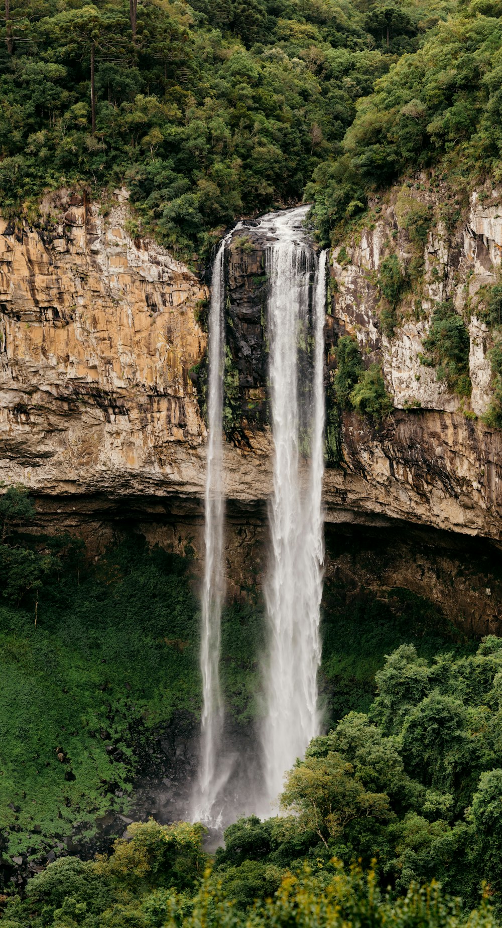 L'acqua cade sulla montagna rocciosa marrone