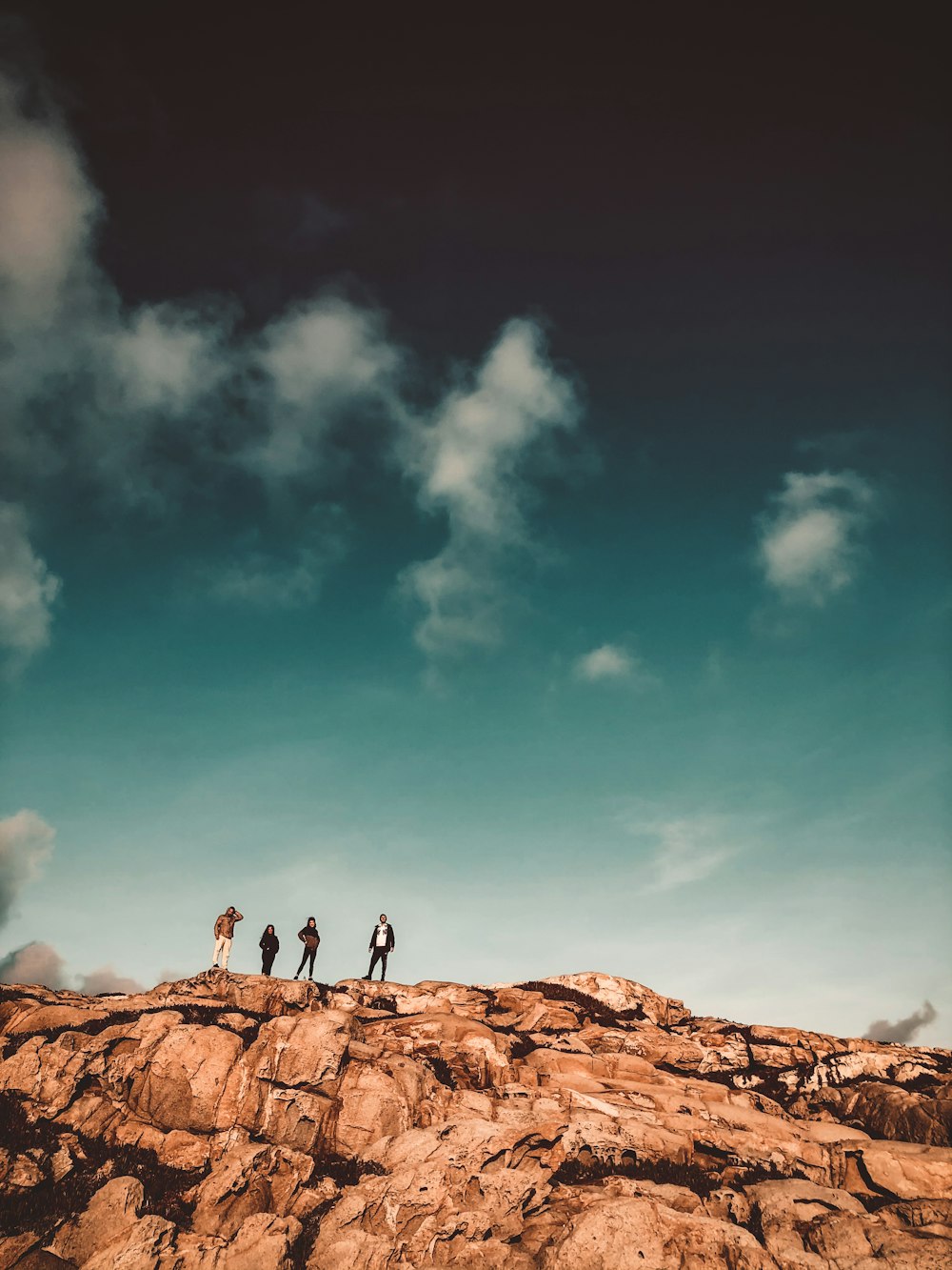 Persona de pie en la roca marrón bajo el cielo azul durante el día
