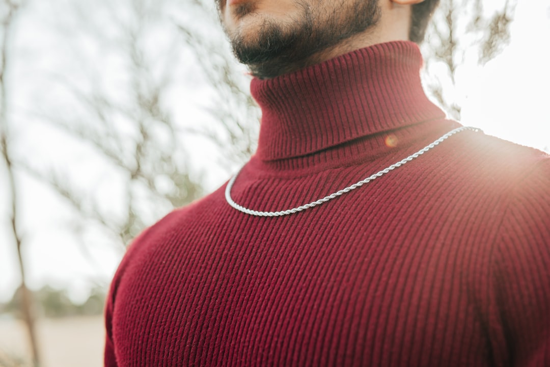 man in red crew neck shirt wearing silver necklace