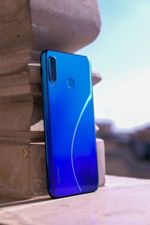 blue smartphone on white concrete surface