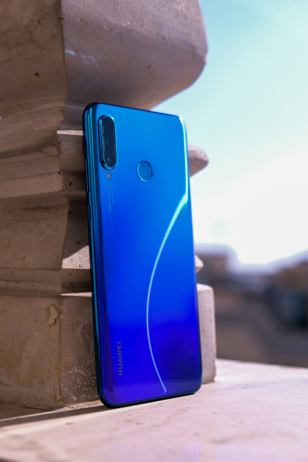 Smartphone azul sobre superficie de hormigón blanco