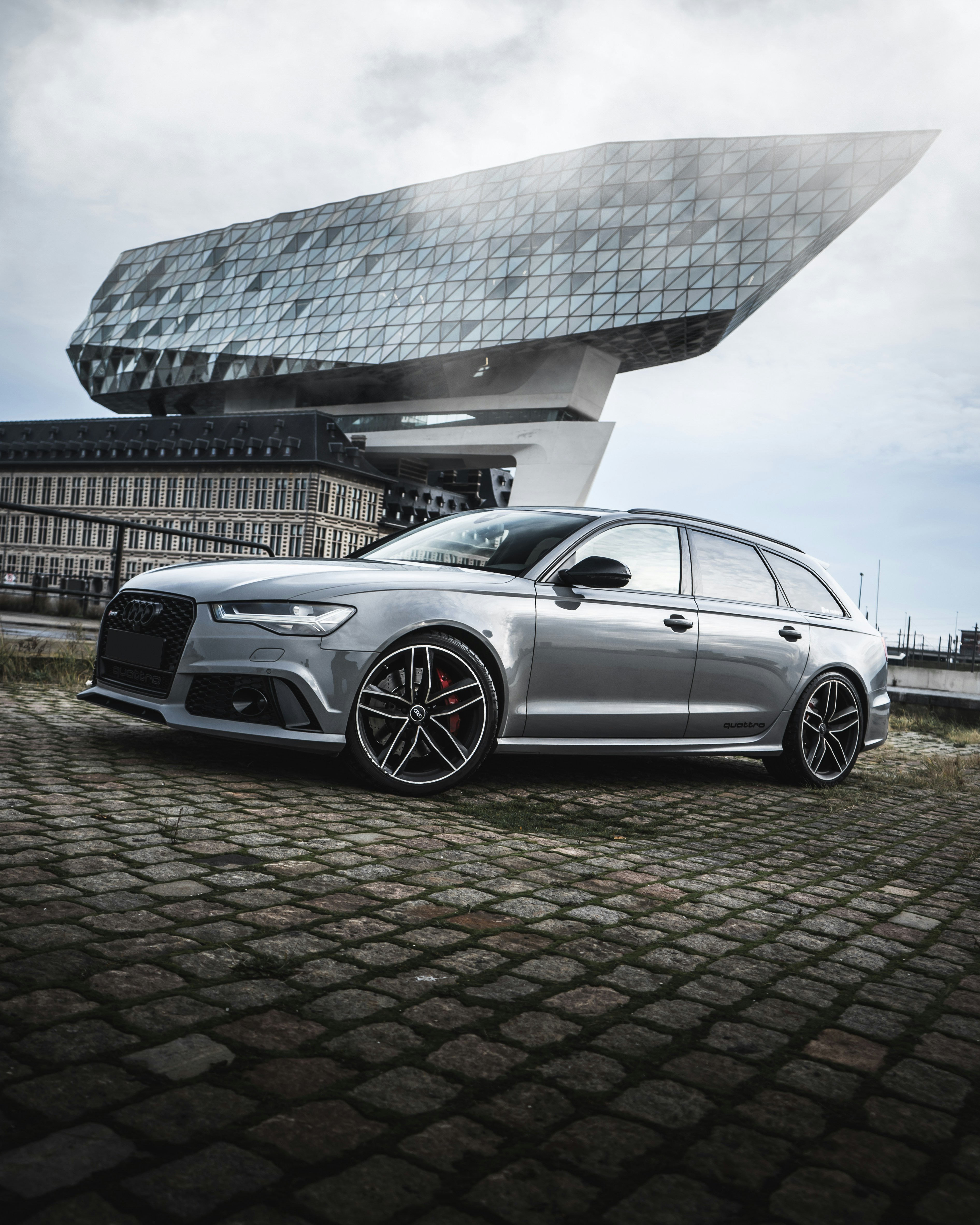 Silbernes Mercedes Benz Coupé tagsüber neben grauem Betongebäude geparkt