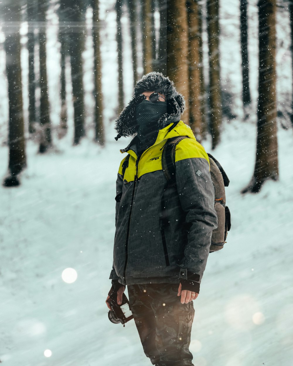 woman in black jacket standing on snow covered ground during daytime